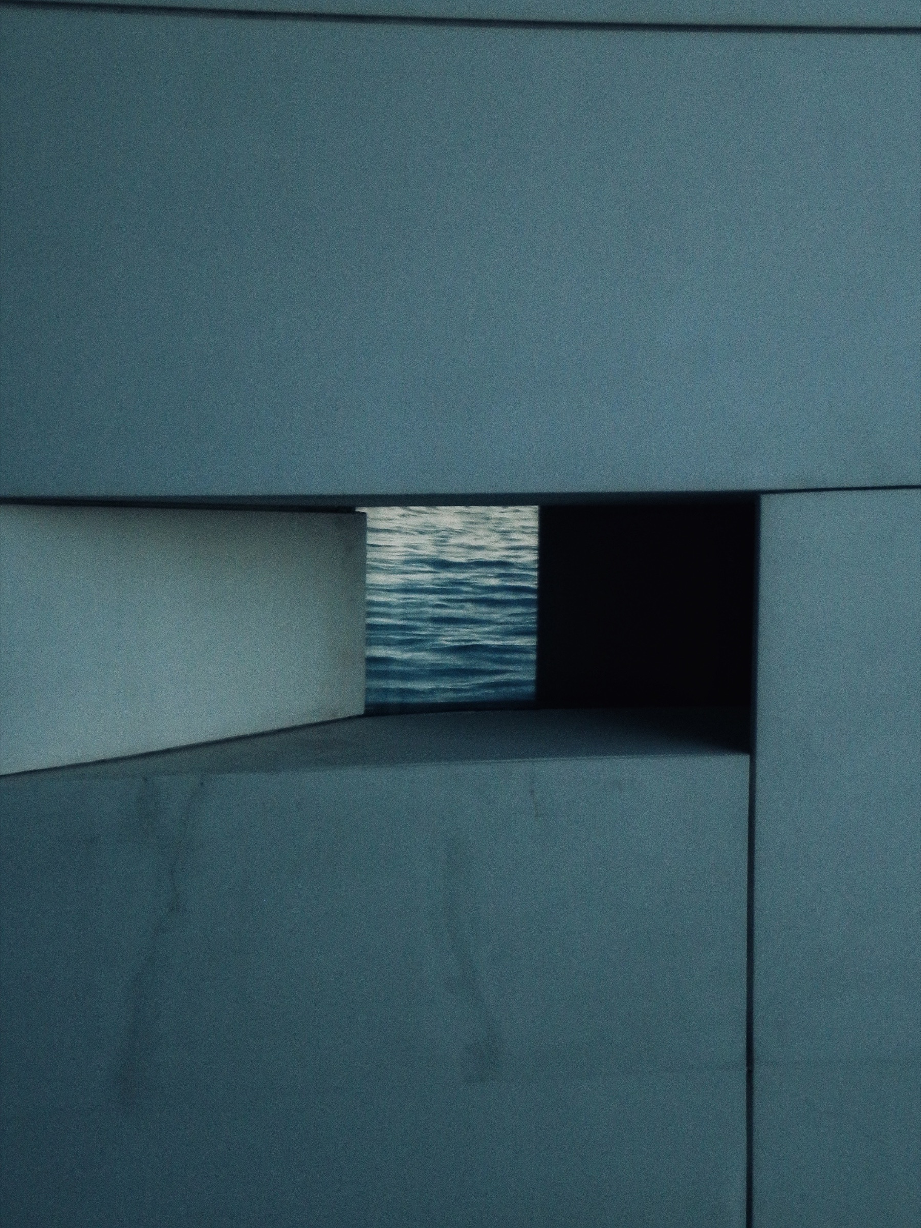 Abstract study of a blue architectural niche revealing a texture of open water