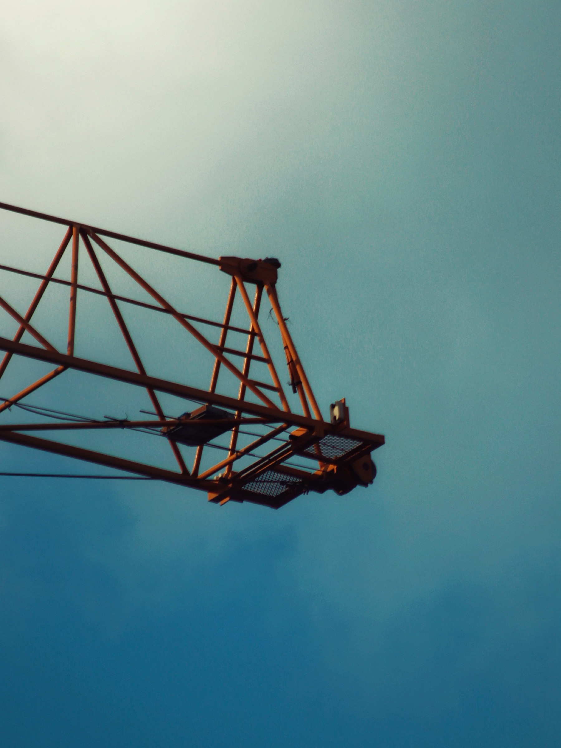 Construction crane arm against a gradient blue sky