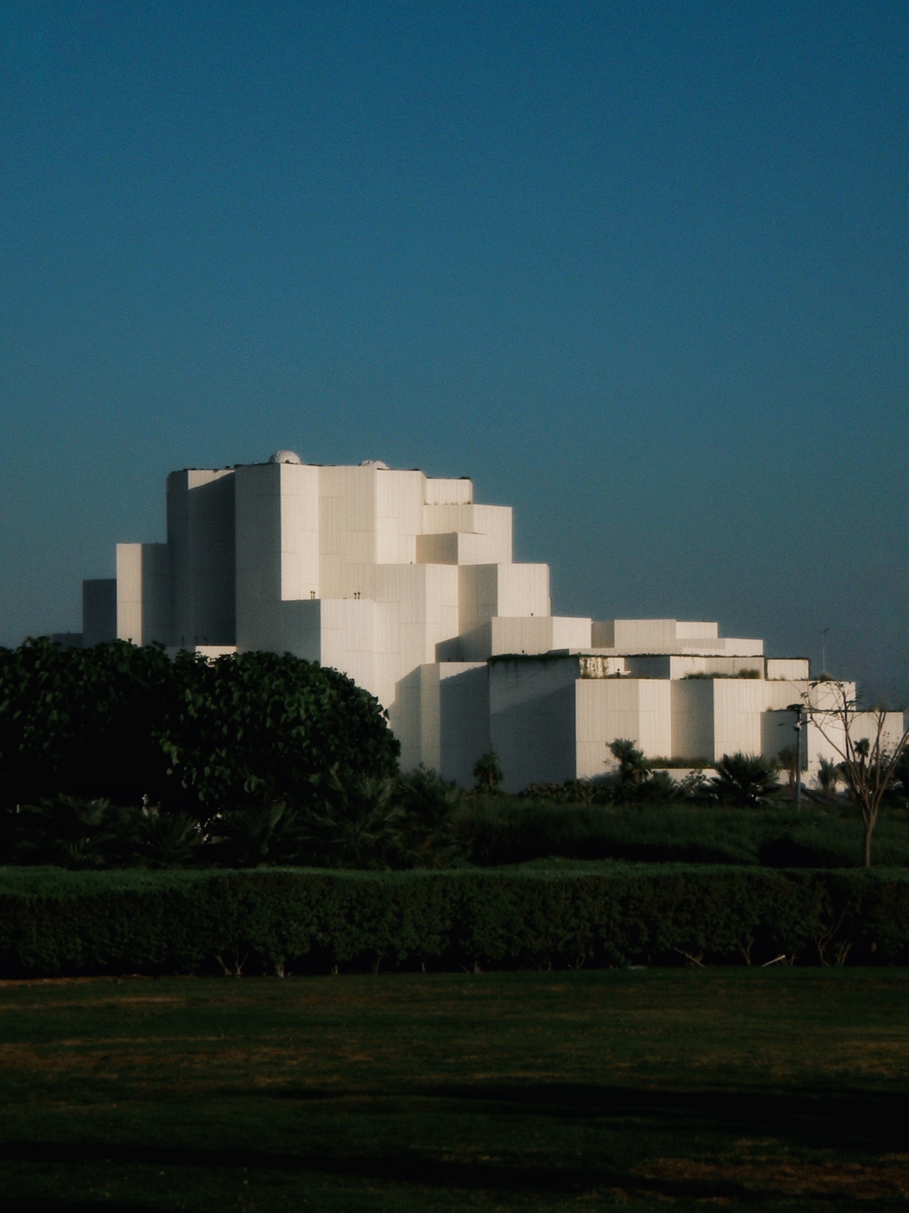 White cubic minimalist building complex in sharp sunlight