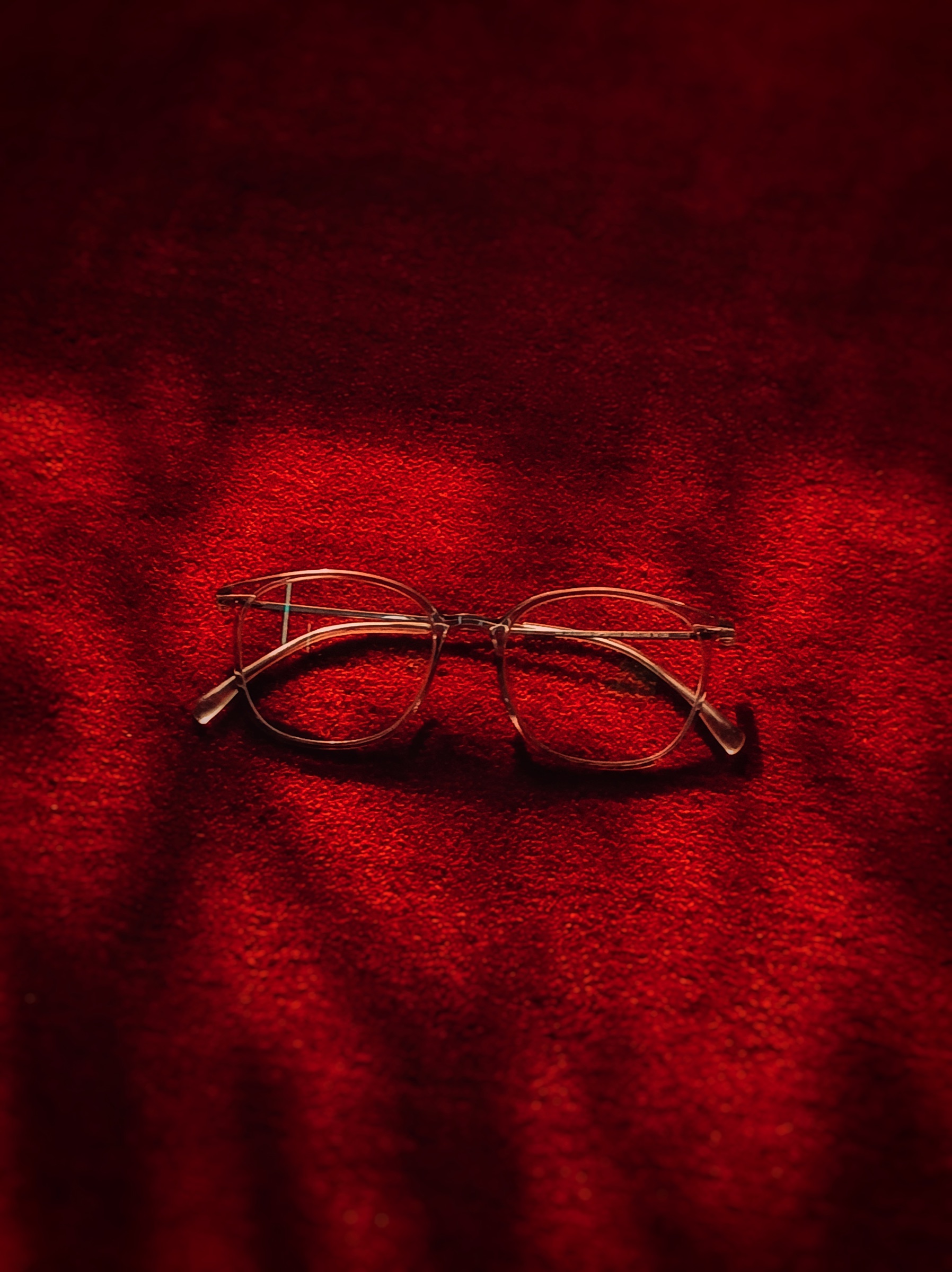 Macro still life of glasses on a red textured surface